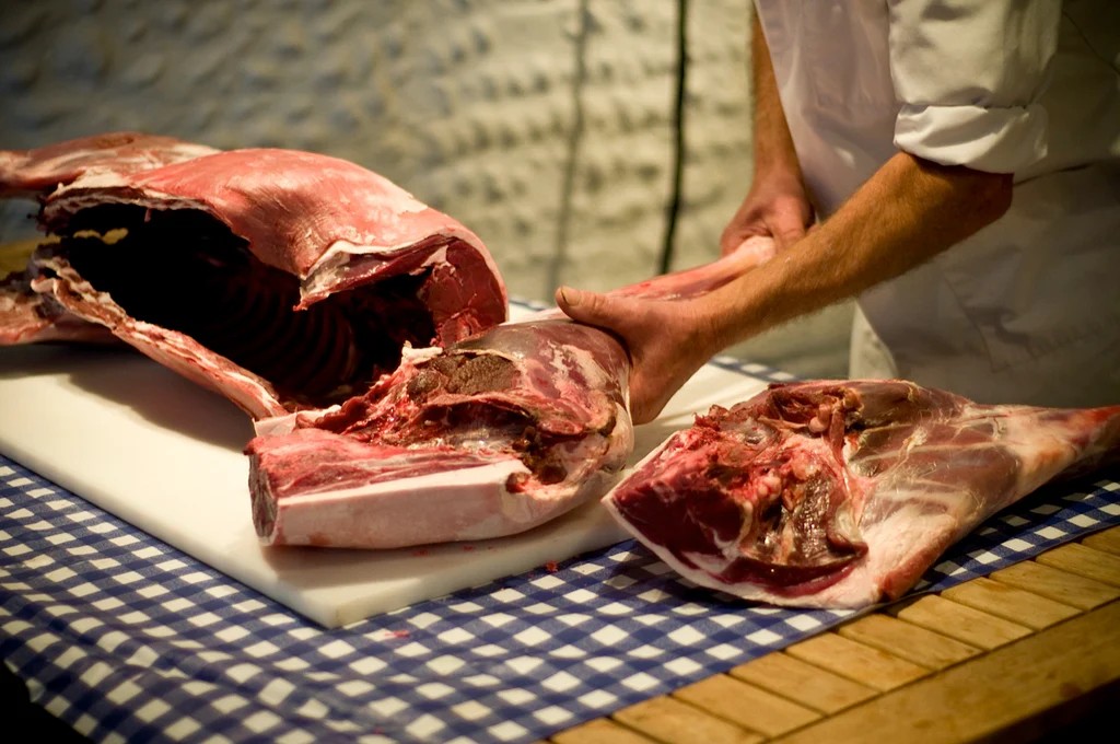 Butcher cutting fresh meat portions